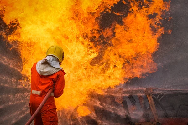 Firefighter are using water in fire fighting operation — Stock Photo, Image