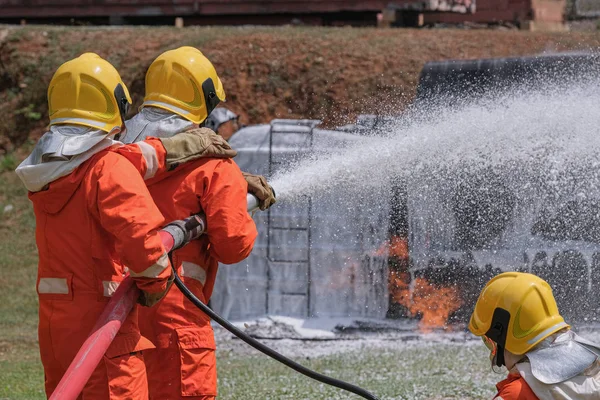 Bombeiros extinguem o fogo com uma espuma química chegando — Fotografia de Stock