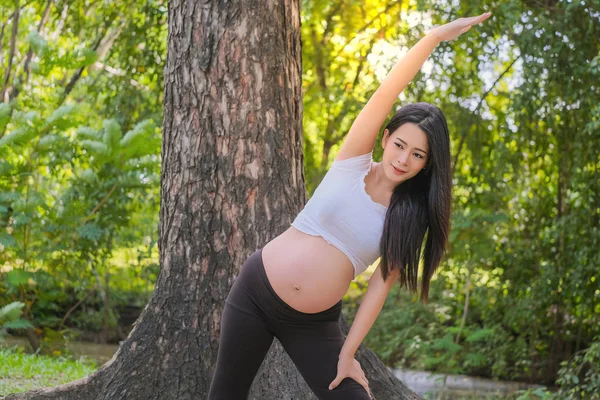 Gravid kvinna gör Yogaövning i naturen på en sommar — Stockfoto