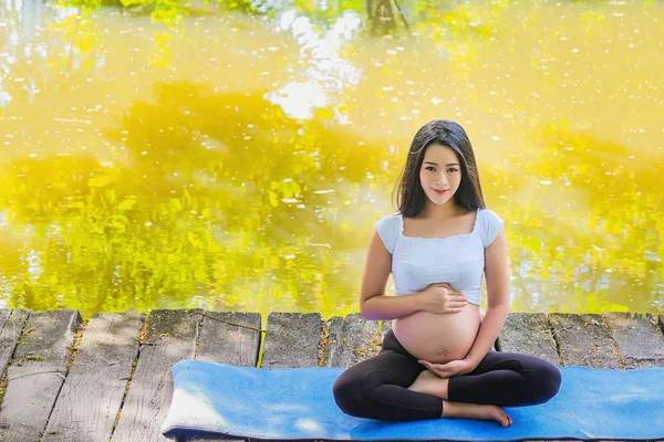 Těhotná žena v letním parku. Čekání na něžnost dítěte — Stock fotografie