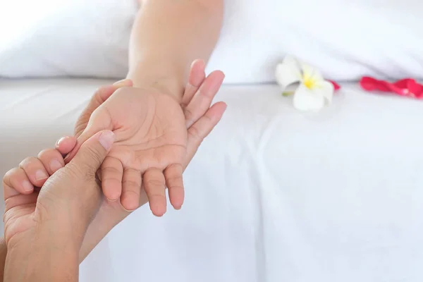 Hand spa massage over clean white bed background - people relax