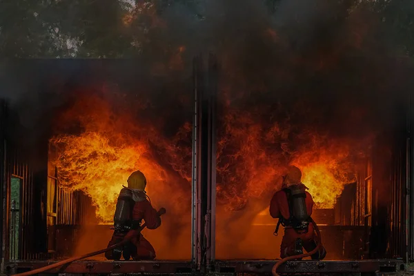 Bomberos extinguidos el fuego está ardiendo ferozmente en el bu —  Fotos de Stock