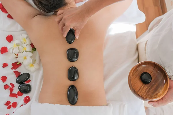 Kobiety z kamieniami terapeutycznymi na plecach — Zdjęcie stockowe