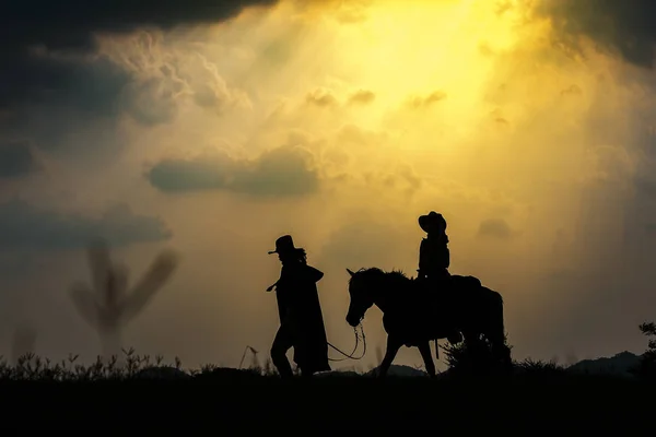 Cowboy silhouet op een paard tijdens mooie zonsondergang — Stockfoto