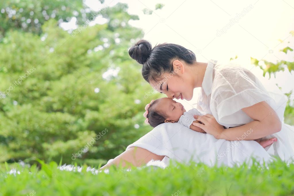 Beautiful mother and baby in an Asian park