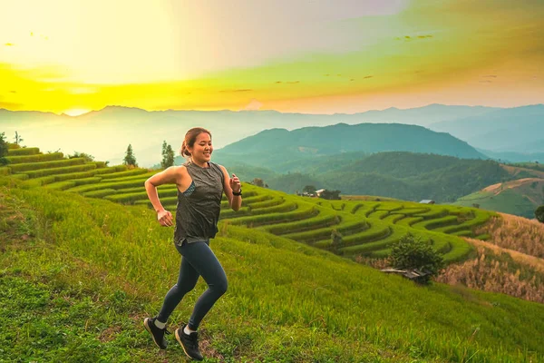 Young women run and run in the fields with mountains and sunsets