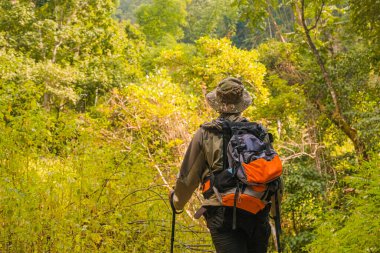 Genç adam bir sırt çantası ve dağcılık direkleriyle büyüdü. Yazın açık havada dağlarda duruyordu..