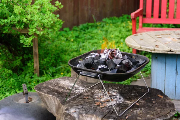 Charcoal BBQ Barbecue Grill  on garden Background. Portable Grillware. Outdoor Cooking Station