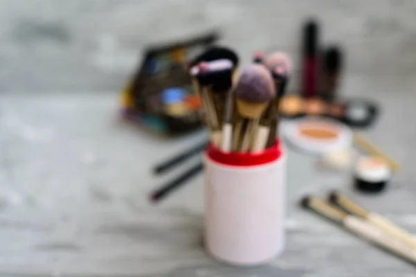 Professional makeup brushes and tools on grey background. Blurres, defocused