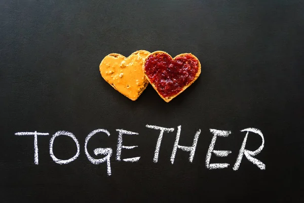 Heart shaped peanut butter and jelly sandwich. Love, valentine concept. Blackboard background