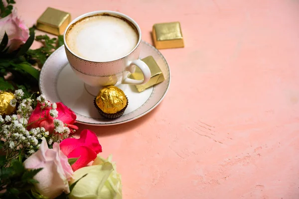 Cup of coffee with flowers on pink