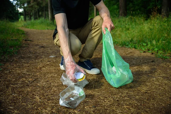 Man collecting garbage in forest