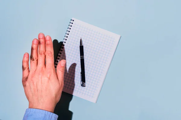 Dirty left hand after writing. Left hander day concept. In blue shirt. Hard light and shadow