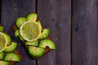 ahşap koyu arka plan üzerinde avokado ile sandviç