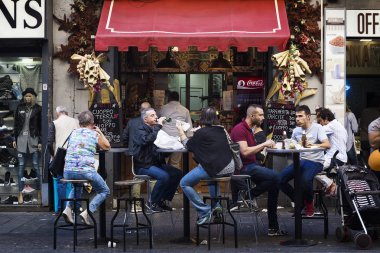 Naples, İtalya - 15 Ekim 2017: Grup sokak masalarında oturup, yemek ve birbirinizle, şehir merkezinde konuşmak insan. Arka sokak gıda dağıtır bir tipik restoran.