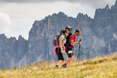 Cortina d'Ampezzo, İtalya - 18 Ağustos 2018: bir aile yürüyüşçü dağ yolu üzerinde yürür, babası oğlu onun omuzlarında taşır. Arka planda Dolomites'in doruklarına.