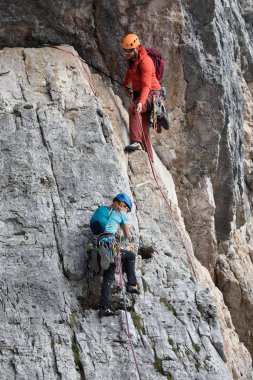 Cortina d'Ampezzo, İtalya - 17 Ağustos 2018: bir erkek ve bir kadın çıplak elle ve halatlar, kayalık bir duvar üstüne tırmanmaya. Konumu Cinque Torri, Dolomites.