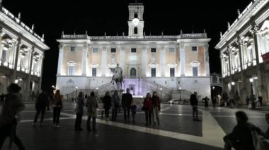 Rome, İtalya - 4 Kasım 2018: Piazza del Campidoglio İmparator Marcus Aurelius atlı heykeli ile. İnsanlar akşam, yapay ışık tarafından aydınlatılmış Meydanı'nda yürüyüş yapın. Palazzo Senatorio, faade arka planda Belediyesi