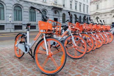 Milan, İtalya - 27 Ekim 2018: Piazza della Scala, üst üste kare üzerinde park edilmiş kiralık bisikletler. Mobike, şehir boyunca servis garanti eder bir şirket portakal ve gümüş Bisiklet gelmektedir.