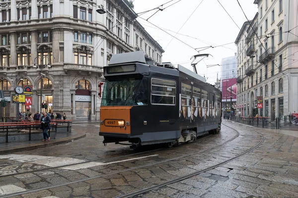 Milan, Italy - October 27, 2018: passing a tram in the city center, the tracks in the road and the suspended cables allow sustainable electric mobility for the city of Milan. The tram is a highly appreciated and historical public transport service in