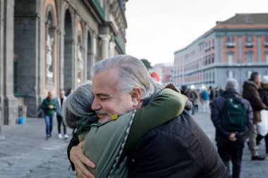 Naples, İtalya - 16th Aralık 2018: Piazza del Plebiscito, barış arasındaki dayanışma belirtisi Caddesi üzerinde iki kişi bir kucaklama. Noel döneminde olduğumuzu.