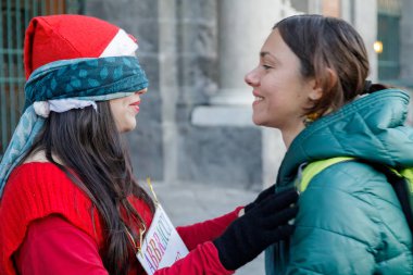 Turist, barış ve dayanışma göstergesi olarak sokakta bir Noel Baba 'ya sarılıyor. Noel dönemindeyiz..