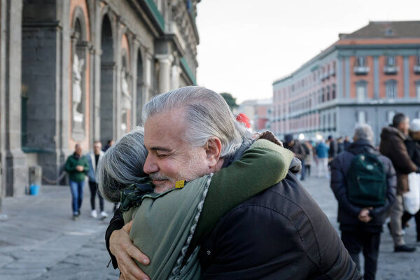 Naples, Italy - December 16th 2018: Piazza del Plebiscito, a hug between two people on the street in a sign of solidarity and peace. We are in the Christmas period.