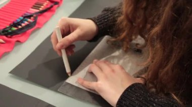 Kız ile cetvel ve kalem, özel bir takım için bir kağıt deseni çizer.