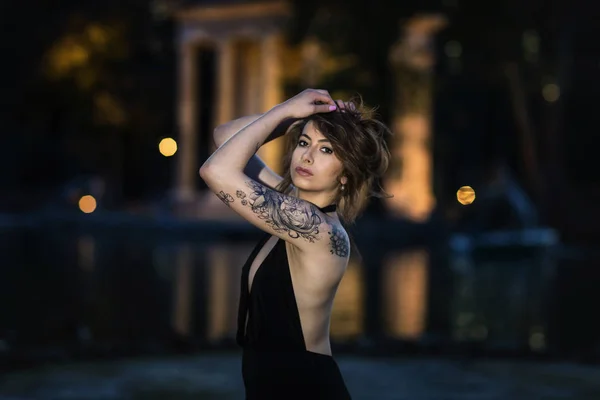 Modèle de mode avec tatouage posant le soir . — Photo