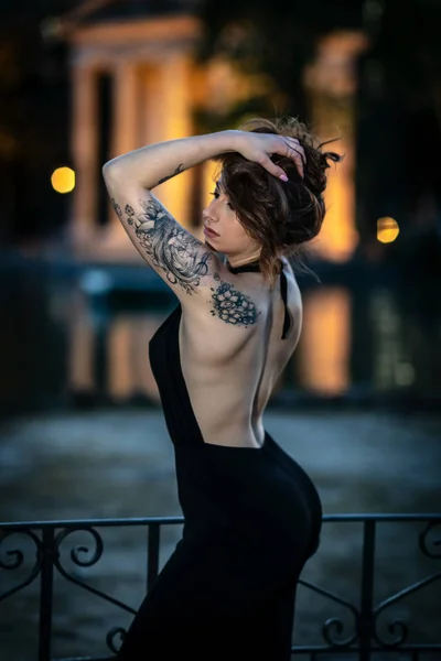 Modèle de mode avec tatouage posant le soir . — Photo