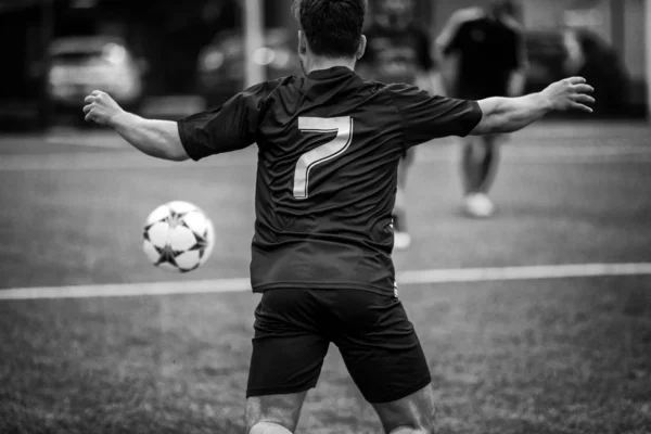 Jugador de fútbol en el campo de fútbol persigue la pelota en una acción — Foto de Stock