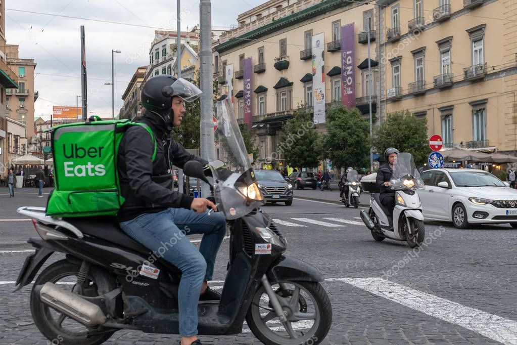 Uber Eats, chico con scooter, entrega comida a casa, con el tipo 2023