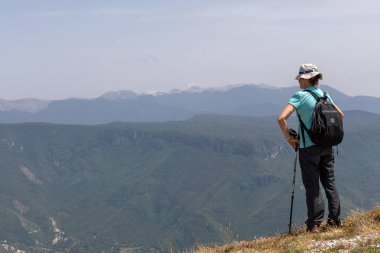 Yürüyüşçü dağın tepesinden manzara hayran.