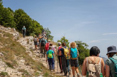 Dağ yolunda yürüyüşçüler grubu.