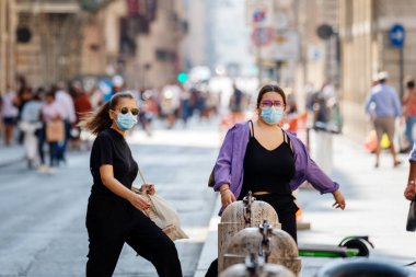 Roma, İtalya - 20 Eylül 2020: Covid-19 salgınından korunmak için şehrin sokaklarında koruyucu maskeler takan insanlar.