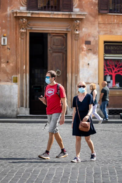 Roma, İtalya - 20 Eylül 2020: Covid-19 salgınından korunmak için şehrin sokaklarında koruyucu maskeler takan insanlar.