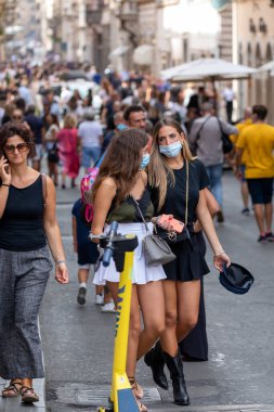Roma, İtalya - 20 Eylül 2020: Covid-19 salgınından korunmak için şehrin sokaklarında koruyucu maskeler takan insanlar.