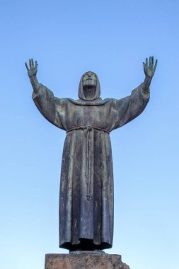 Assisi Aziz Francis anıtı (1182-1226), Roma, İtalya 'da. Açık mavi arkaplanda bronz heykel.