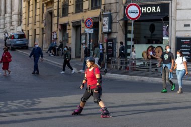 Roma, İtalya - 10 Ekim 2020: Bir kadın paten kayarak şehir sokaklarında dolaşıyor.