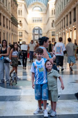 Naples, Italy - September 12, 2025: Two children are photographed at the entrance to the majestic Galleria Umberto I, a historic monument in the city.