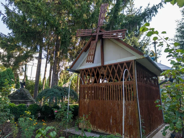 Üstünde yel değirmeni olan küçük bir ahşap kulübe..