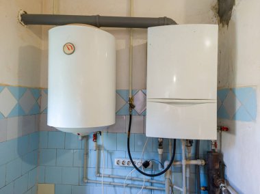A tankless water heater in a bathroom next to a toilet.