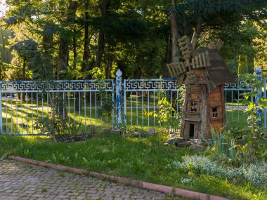 Bahçenin ortasında çitin yanında küçük ahşap bir yel değirmeni..
