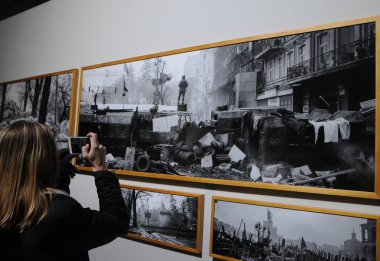 The girl takes photographs of the historical days of the Revolution of Dignity during the Revolution Exhibition at the Artistic Arsenal, in Kiev, November 21, 2018.  clipart