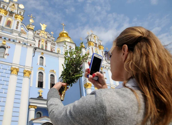女の子は キエフの聖ミカエル大聖堂を背景にパーム日曜日に柳の枝の写真を撮ります 2019 — ストック写真
