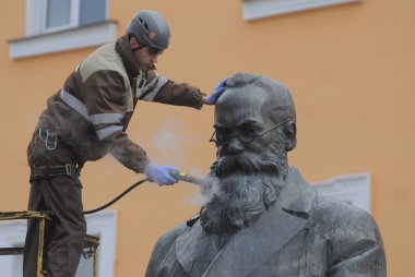Bir temizlik şirketi çalışanı Kiev Mikhail Hrushevsky için anıt yıkıyor, Mart 16, 2017