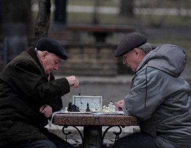 Yaşlılar Kiev'deki Shevchenko Park'ta satranç oynuyor15/03/2017