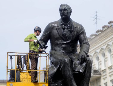 Bir işçi Kiev Wash A Monument flashmob bir parçası olarak Temiz Gün eylem sırasında Ukraynalı besteci Nikolai Lysenko için bir anıt yıkar, Nisan 28, 2017.