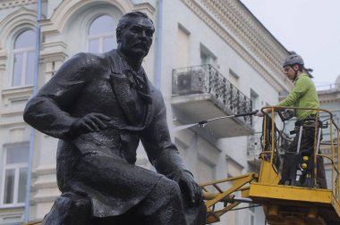 Bir işçi Kiev Wash A Monument flashmob bir parçası olarak Temiz Gün eylem sırasında Ukraynalı besteci Nikolai Lysenko için bir anıt yıkar, Nisan 28, 2017.