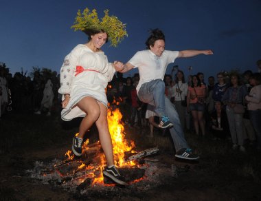 Gençler Pirogovo Ivan Kupala kutlamaları sırasında ateşin üzerinden atlamak, Kiev, Temmuz 6, 2019